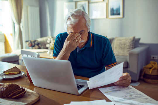 Senior man stressed about finances and bills at home