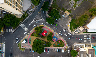 Small square with parking and cars passing around - obrazy, fototapety, plakaty