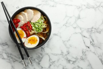 Delicious ramen in bowl on white marble table, top view with space for text. Noodle soup