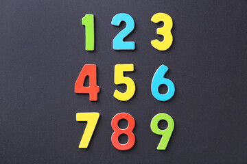 Colorful numbers on black background, flat lay