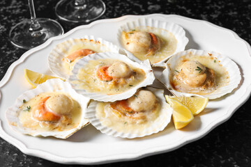 Fried scallops in shells on black table, closeup