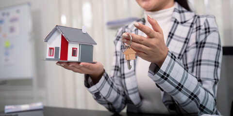 Real estate agent with house model and key