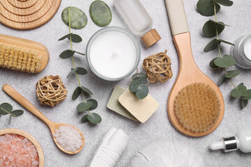 Flat lay composition with spa products and eucalyptus branches on light grey table