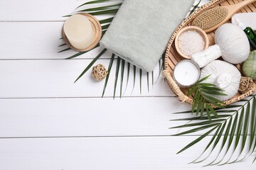 Flat lay composition with candle and different spa products on white wooden table. Space for text