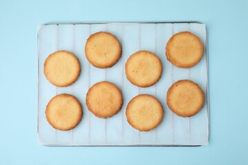 Tasty sweet sugar cookies on light blue background, top view