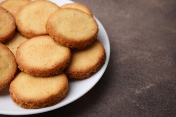 Tasty sweet sugar cookies on brown table, closeup. Space for text