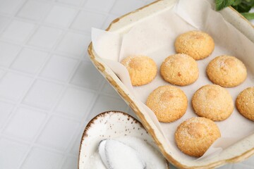 Tasty sweet sugar cookies in baking dish on white tiled table, closeup. Space for text