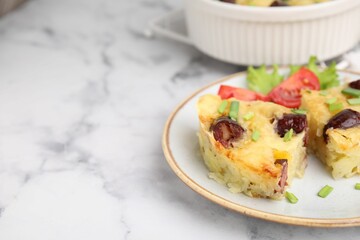 Tasty sausage casserole with green onions and vegetables served on white marble table, closeup. Space for text