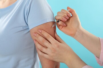 Diabetes. Woman getting insulin injection on light blue background, closeup