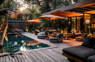 Fototapeta na wymiar modern outdoor patio with pool, wood deck, couches and chairs, sunset, umbrellas, lush landscaping