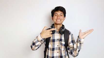 happy young asian man posing pointing at his palm with an isolated white background