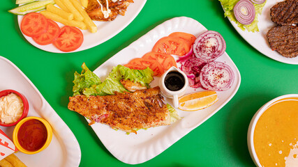 Fried fish fillet and vegetables on plate assortment