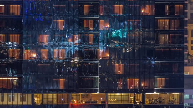 Office and residential buildings windows illuminated at night timelapse. Glass architecture, conference hall and restaurant in corporate building at evening with glowing orange lights