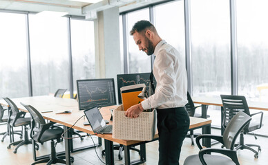 With box in hands. Unemployed man is with personal belongings after being fired