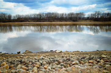 Stony river bank during early spring landscape backdrop - 780679907