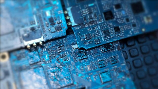 Extreme close up computer motherboard components background in blue light tracking shot side view. Circuit board surface. Mainboard and chip technology. 