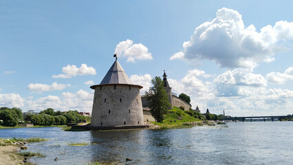 Ancient stone tower with wooden roof of Kremlin on embankment of Velikaya river. Pskov, Russia. Old...