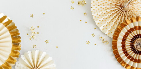 Birthday background banner template mock up  top view with colden fan paper decor and gold stars confetti on white backdrop. Copy space. Holiday, wedding, party background.