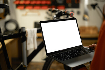 men using laptop computer working in garage or workshop with blank white desktop screen.