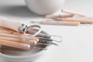 Set of different clay crafting tools on white table, closeup. Space for text