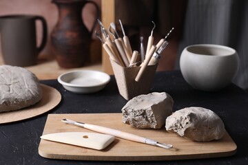 Clay and set of modeling tools on table in workshop