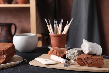 Clay and set of modeling tools on table in workshop