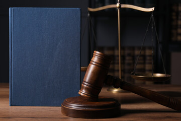Law. Book, gavel and scales on wooden table