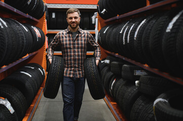 Man chooses winter car tires in the auto shop - Powered by Adobe