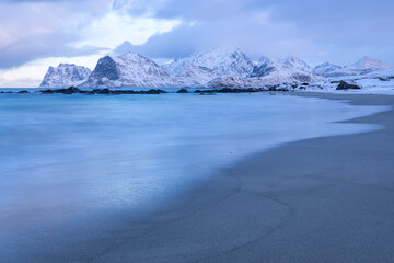 sanft treffen die Wellen auf den Strand bei Storsandnes, winter auf den Lofoten, schneebedecktes...