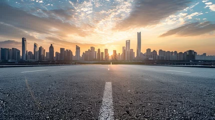 Tuinposter As the sun rises, a panoramic skyline emerges, adorned with sleek modern commercial buildings. Below, an empty asphalt road winds through the cityscape © Azad