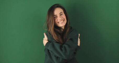 Come into my arms. Adorable happy girl with brown hair in green gesturing come here for free hugs and smiling sincerely with welcoming expression isolated on green background. Come to me, hug self.