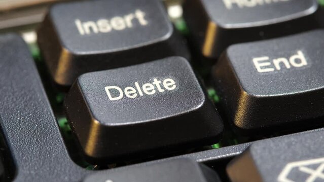 Focus on a delete key on a simple laptop computer keyboard, object macro detail, extreme closeup, nobody. Deleting files, removing content, digital data deletion simple abstract concept symbol