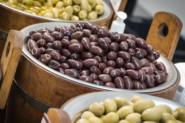 Fresh olives in barrels on street market or in grocery shop. Snack containing vitamins