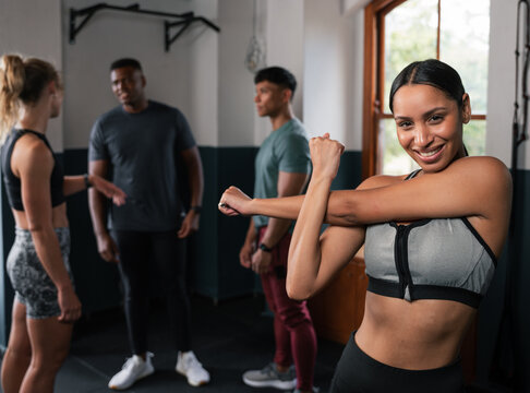 People in gym stretching arms, showing muscle strength, smiling