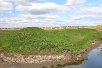 A grassy hill next to a body of water