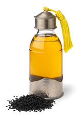 Single Moroccan bottle with Nigella oil and a heap of nigella seed on white background close up
