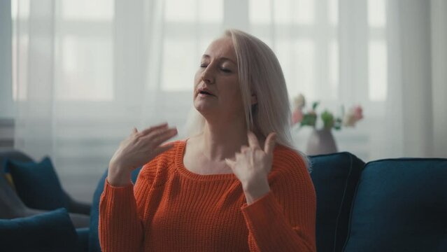 Middle-aged woman suffering from a hot flash, heavy sweating, menopause symptom