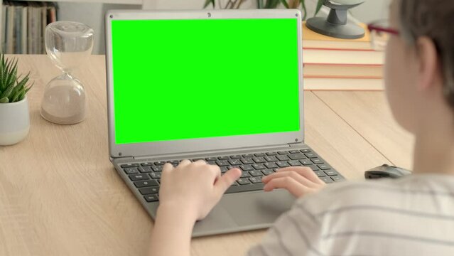 smart child, schoolboy playing with computer, developing brain games, monitor with empty green screen mockup, digital age, cyber education, concept childhood, child development, self-education