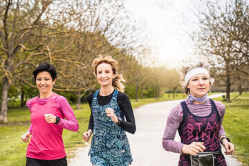 Three Multigenerational happy women running at the park - Group of female runners training outdoors...