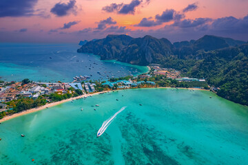 Aerial view sunset landscape longtail boat on Phi Phi island from drone, travel landmark of Thailand