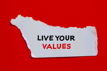 Live your values words written on white torn paper piece with red background. Conceptual symbol....