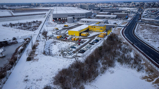 Weiterstadt, Germany January 19, 2024: View over the DHL delivery station Weiterstadt with Metro, Segmüller in winter with snow