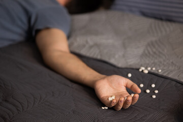 Man lying bed from overdose antidepressants and somnifacient. Psychological and mental problems,...