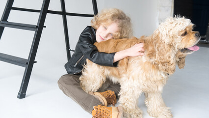 Young Child Embracing a Fluffy Golden Dog in a Bright Studio Setting