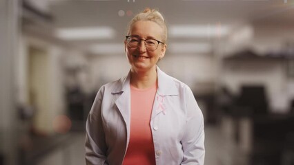 Portrait of a woman doctor with pink ribbon, breast cancer awareness, check-up