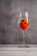 A comical skull face down trying to drown in a glass of water