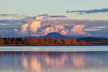 The shoreline of a lake frames Spencer Butte in the background o