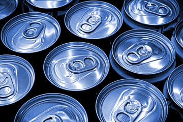 Lots aluminum soda or beer cans as background. Blue tone image.