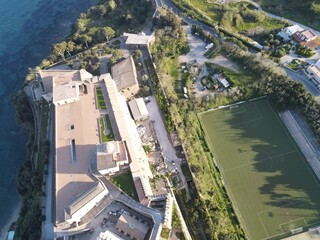 Obraz premium Explore the stunning coastline of a Southern Italian city Baia through breathtaking drone footage: crystal-clear waters, rugged cliffs, and colorful houses blend into an enchanting landscape
