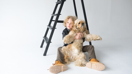 Boy sitting on stepladder holding dog